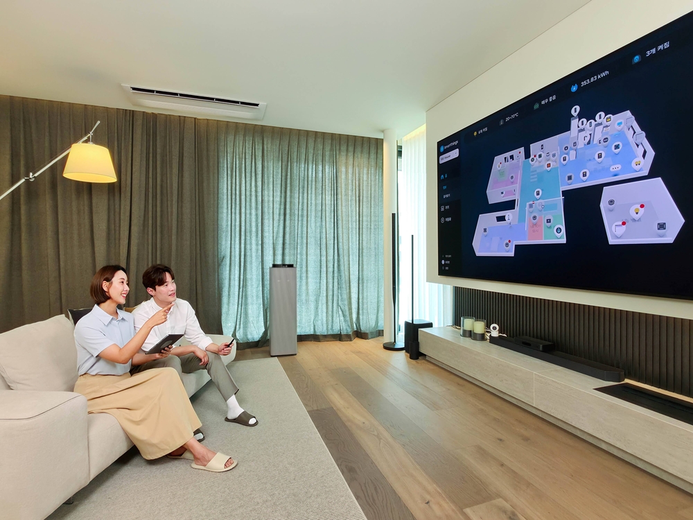 삼성 AI 모듈러 홈 쇼룸 거실에서 TV의 스마트싱스 맵뷰를 살펴보는 모델들
